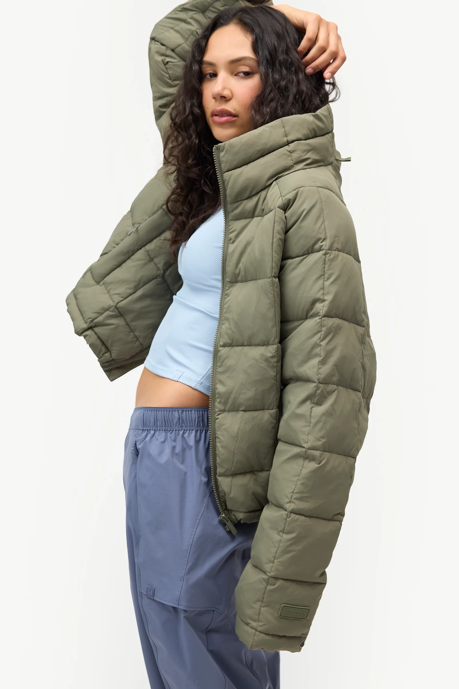 Olive Nellie Packable Puffer Jacket worn with blue pants