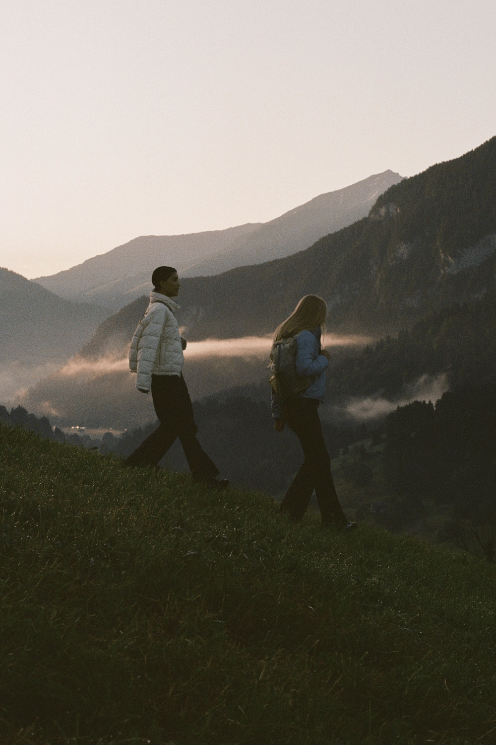 Two hikers on a ridge at dusk
